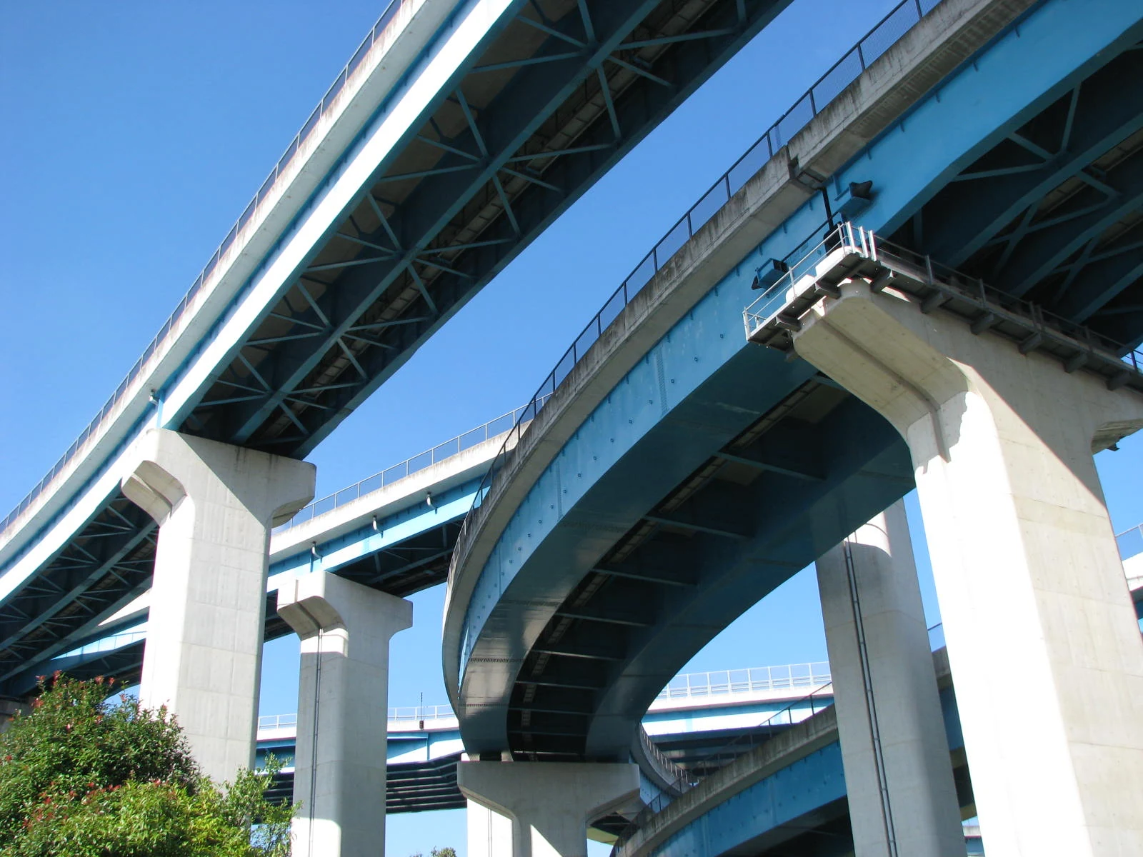 青空に向かって重なり合う高架道路と橋脚